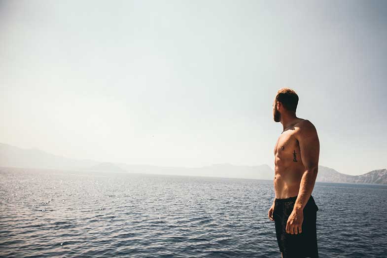 Man With Abs Wearing Black Shorts Looking at Water