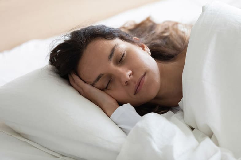 Woman Lying in Bed Sleeping on Side