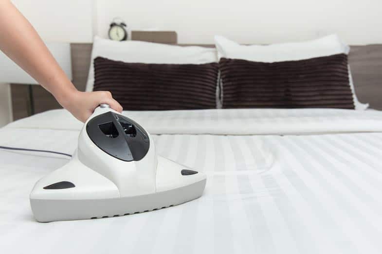 Bug Vacuum Cleaner on Bed Mattress