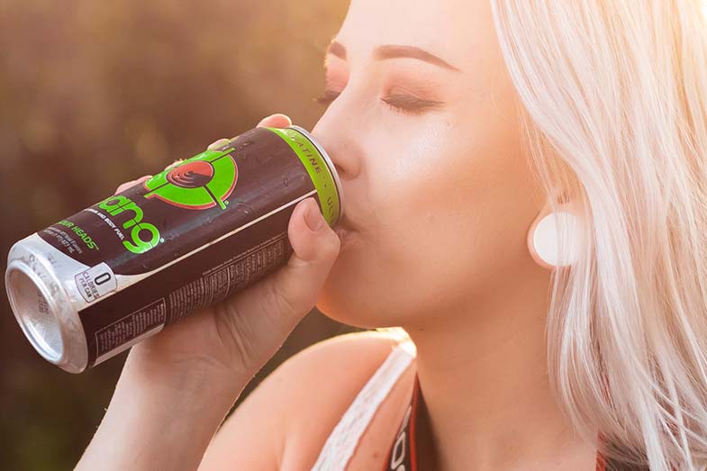 Woman Drinking Energy Drink from a Tin Can Outside